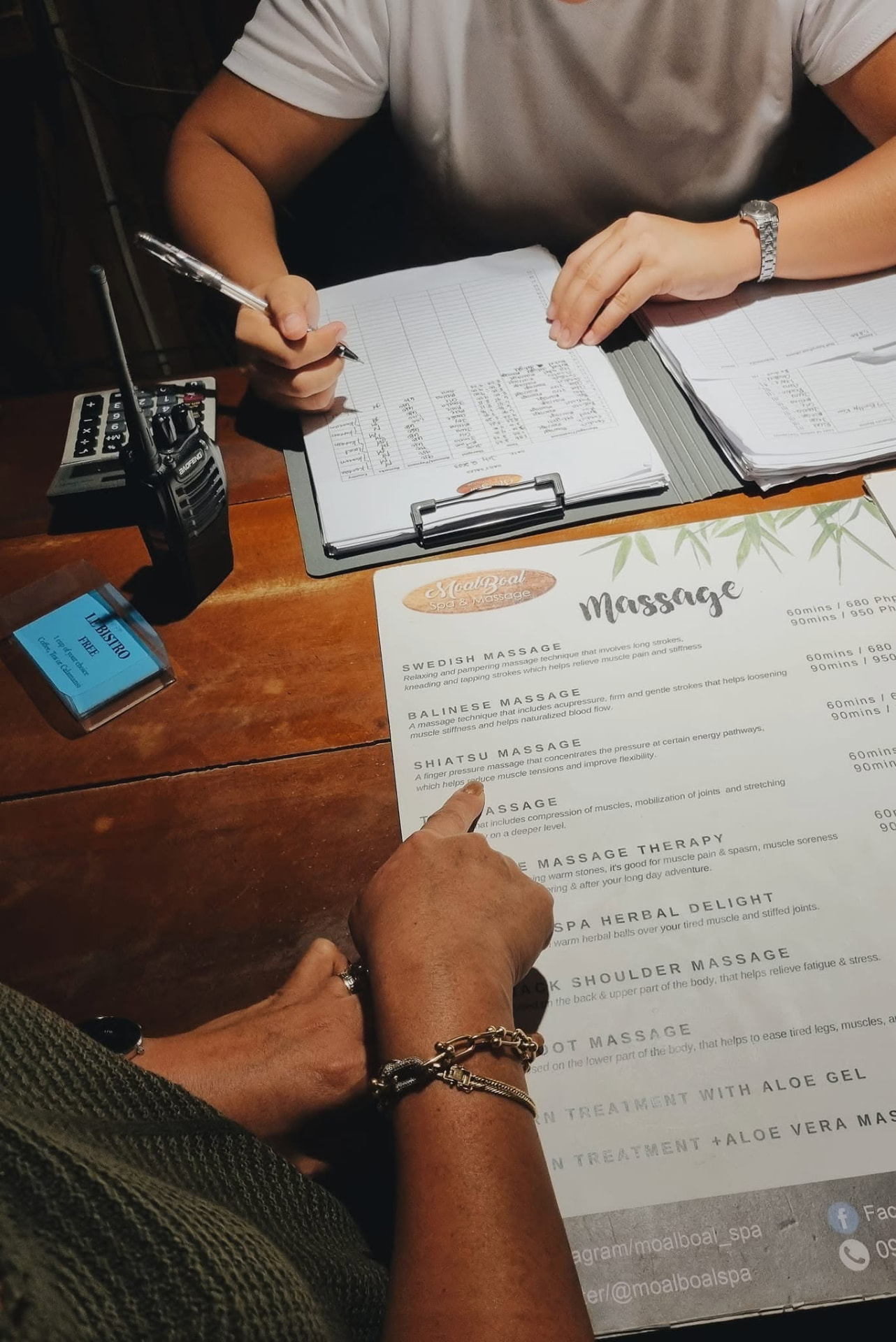 Choosing a massage from the menu at the reception desk